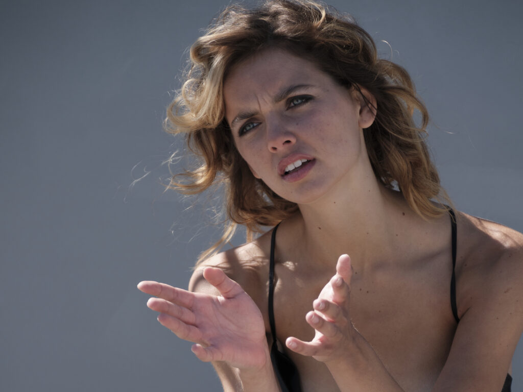 Cineastisches Farbfoto Fine Art Portrait einer Frau mit ausdrucksstarker Handgestik und natürlichem Lichtspiel