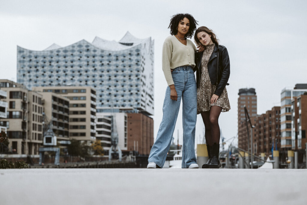 Zwei Models posieren stilvoll vor der Kulisse der Elbphilharmonie in Hamburg