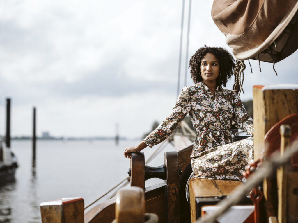 Model Clara im Blumenkleid an Deck eines Tradionsschiffs in der Hamburger HafenCity