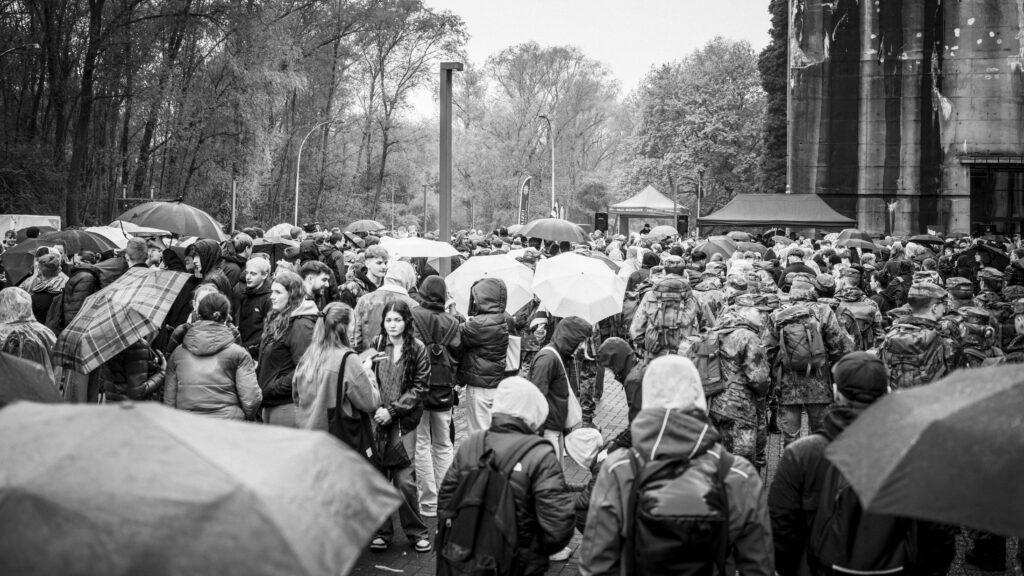 Große Menschenmenge mit Regenschirmen vor dem Bunker Valentin beim Auftakt des Gedenkmarsches.