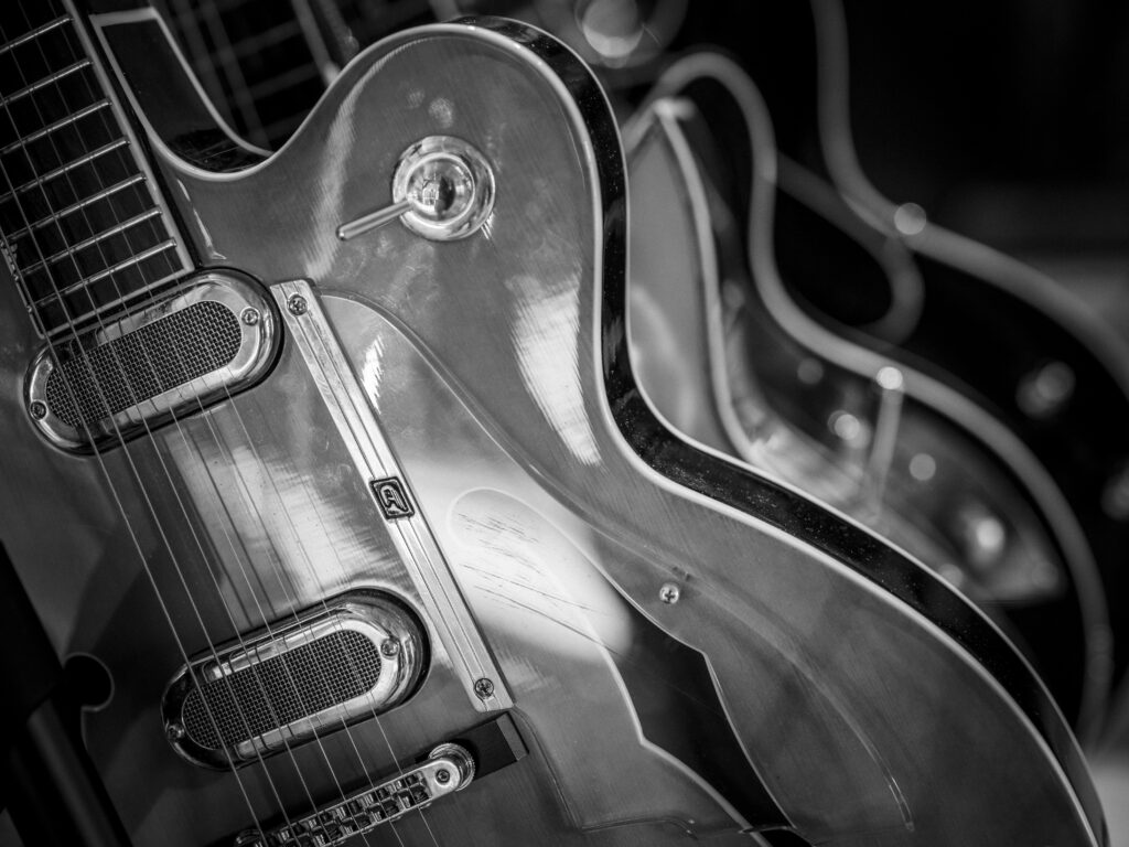 Nahaufnahme des Glanzes und der Details des Korpus einer Semihollow-E-Gitarre bei einem Live-Konzert in Schwarz-Weiß.