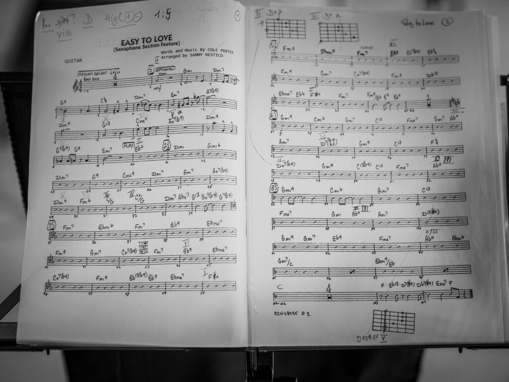 Aufgeschlagenes Notenbuch auf einem Notenständer für Gitarre mit dem Arrangement Easy to Love bei einer Bigband-Probe.